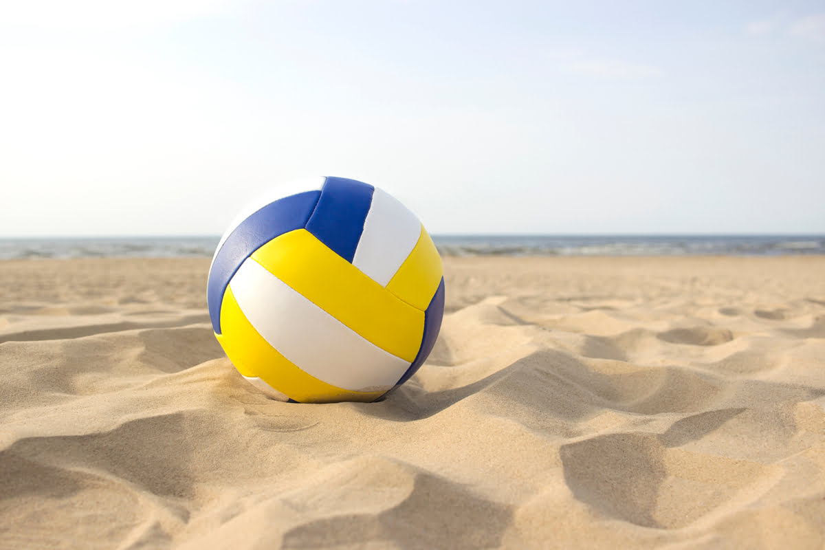 TheBallLiesOnASunnyBeach Grupa przyjaciół grająca w siatkówkę plażową